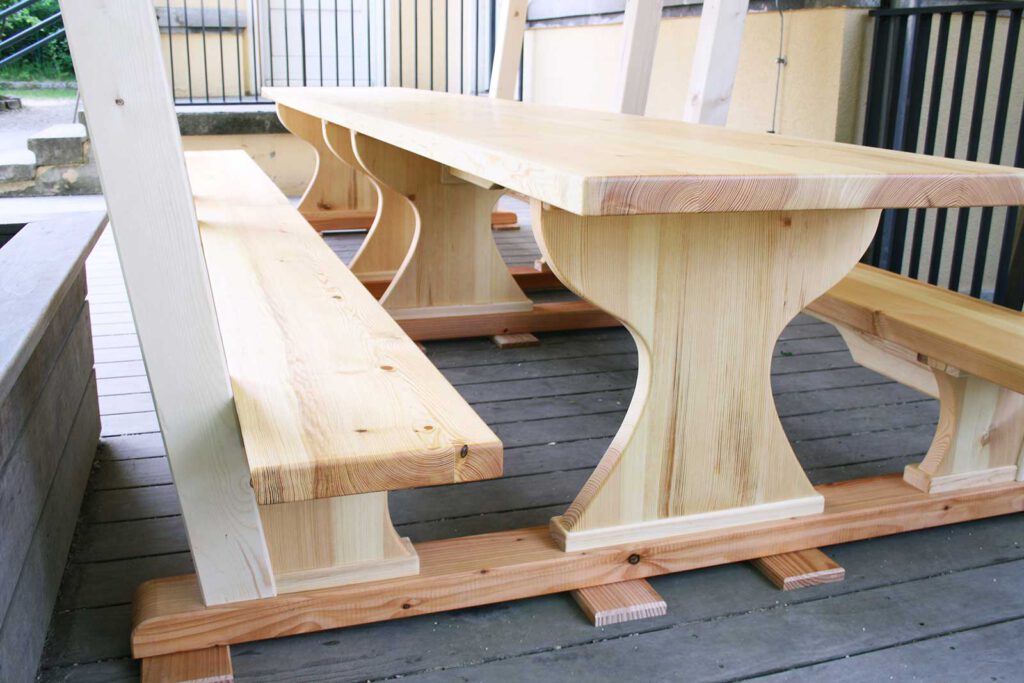 Tische und Bänke aus Holz auf der Terrasse im Garten. Nahaufnahme und Holzmaserung